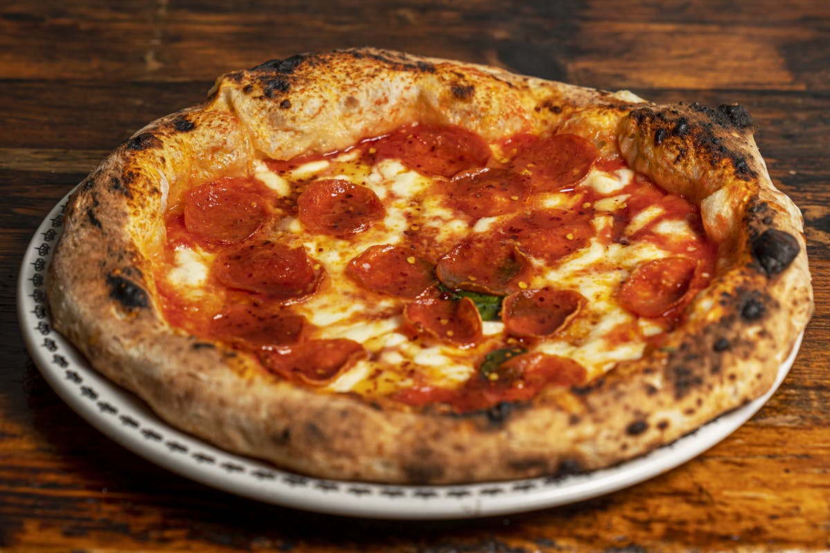 a pizza sitting on top of a wooden table